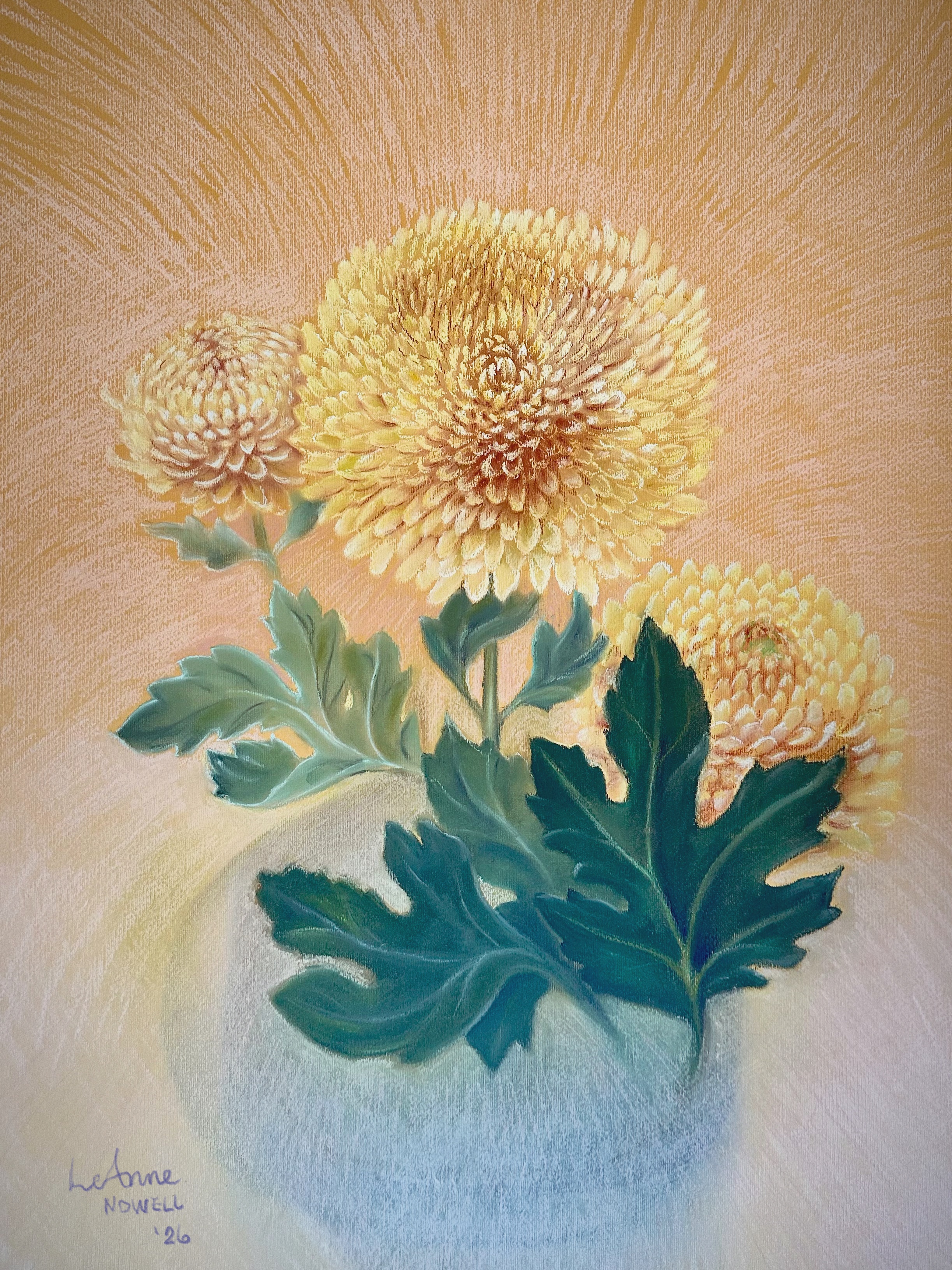 Original pastel painting of three golden-yellow chrysanthemum flowers with deep green foliage in a soft vase against a warm sunburst background.